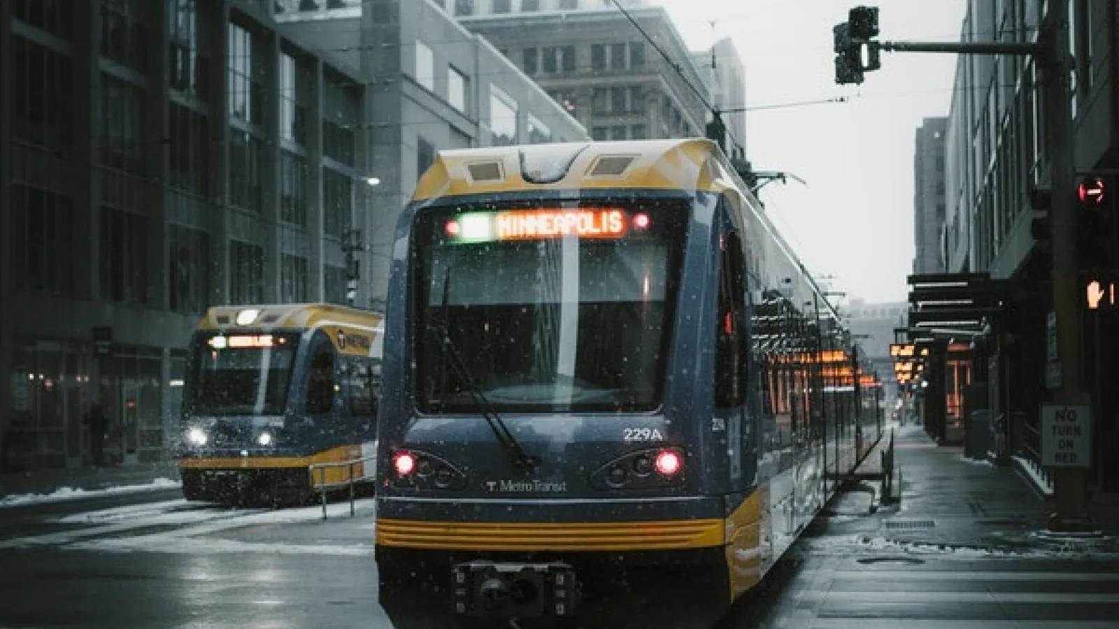 Streetcars on a rainy day in the city with buildings on either side
