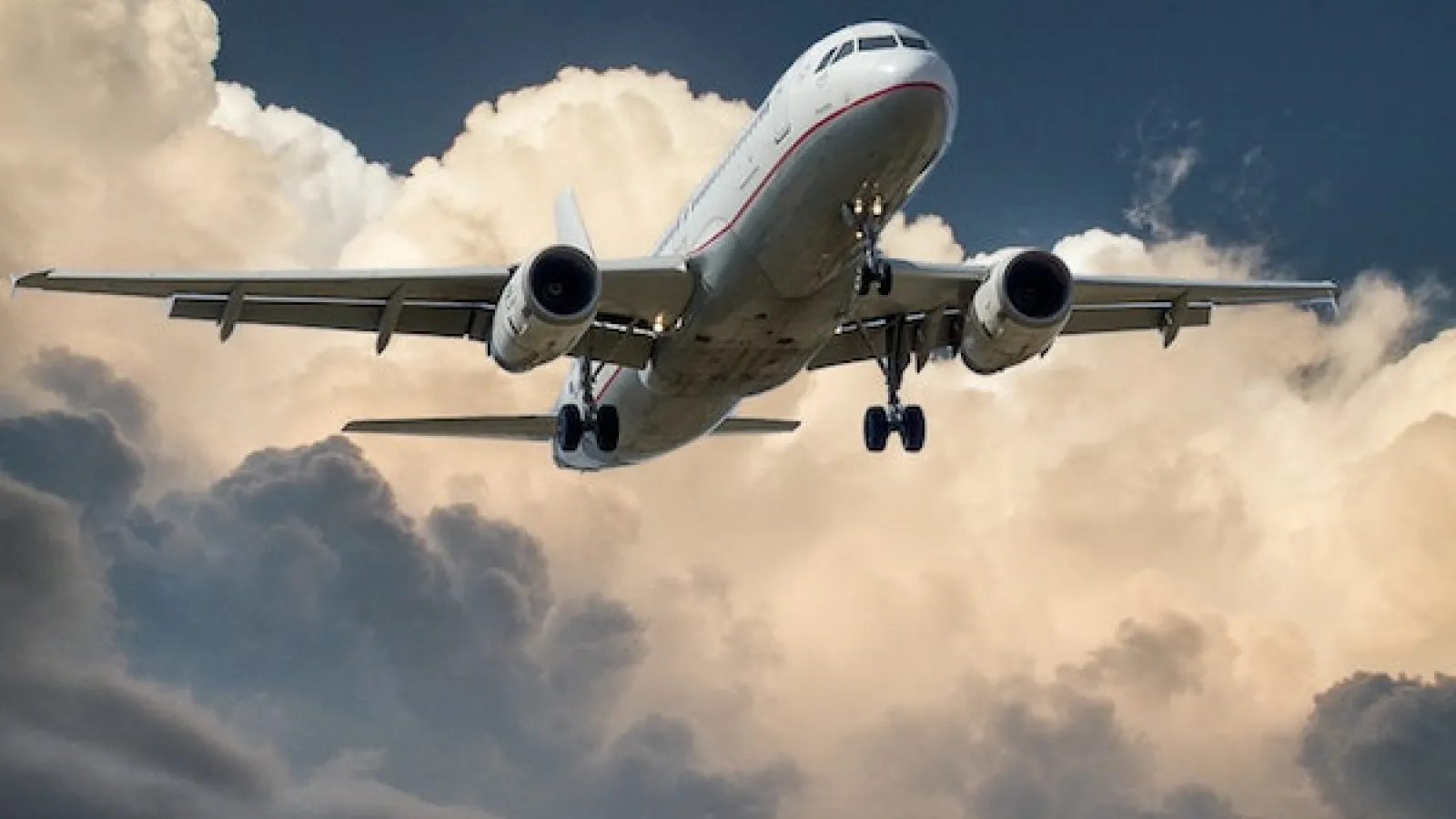 White and Red Plane Beside Clouds Low-angle Photography