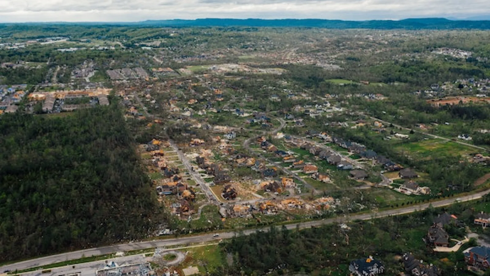 Tornado damage area with houses and uprooted trees