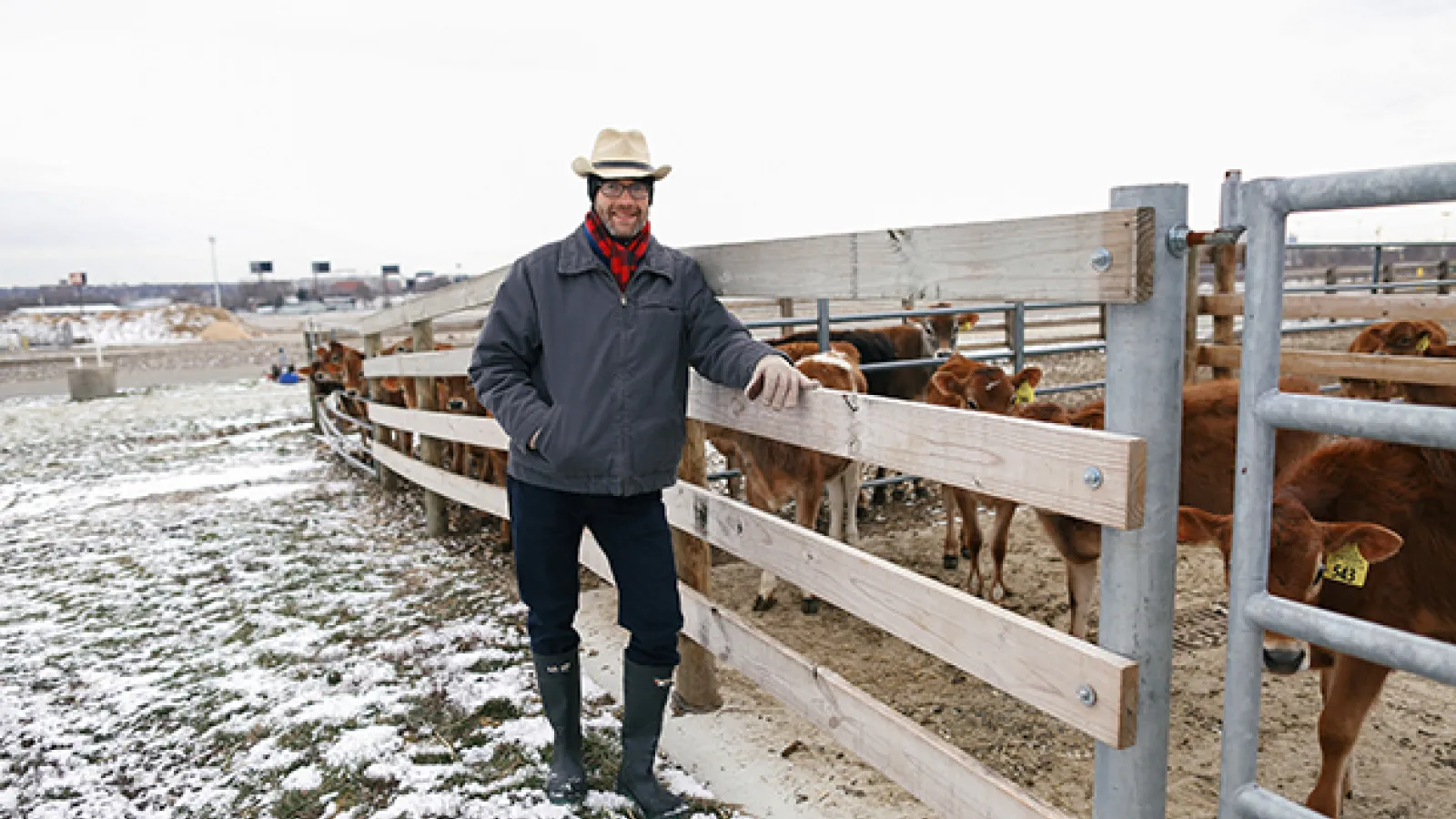 State Climatologist Bryan Mark stands in front of a line of dairy cows at Watermand Farm on a cold, cloudy February day. 