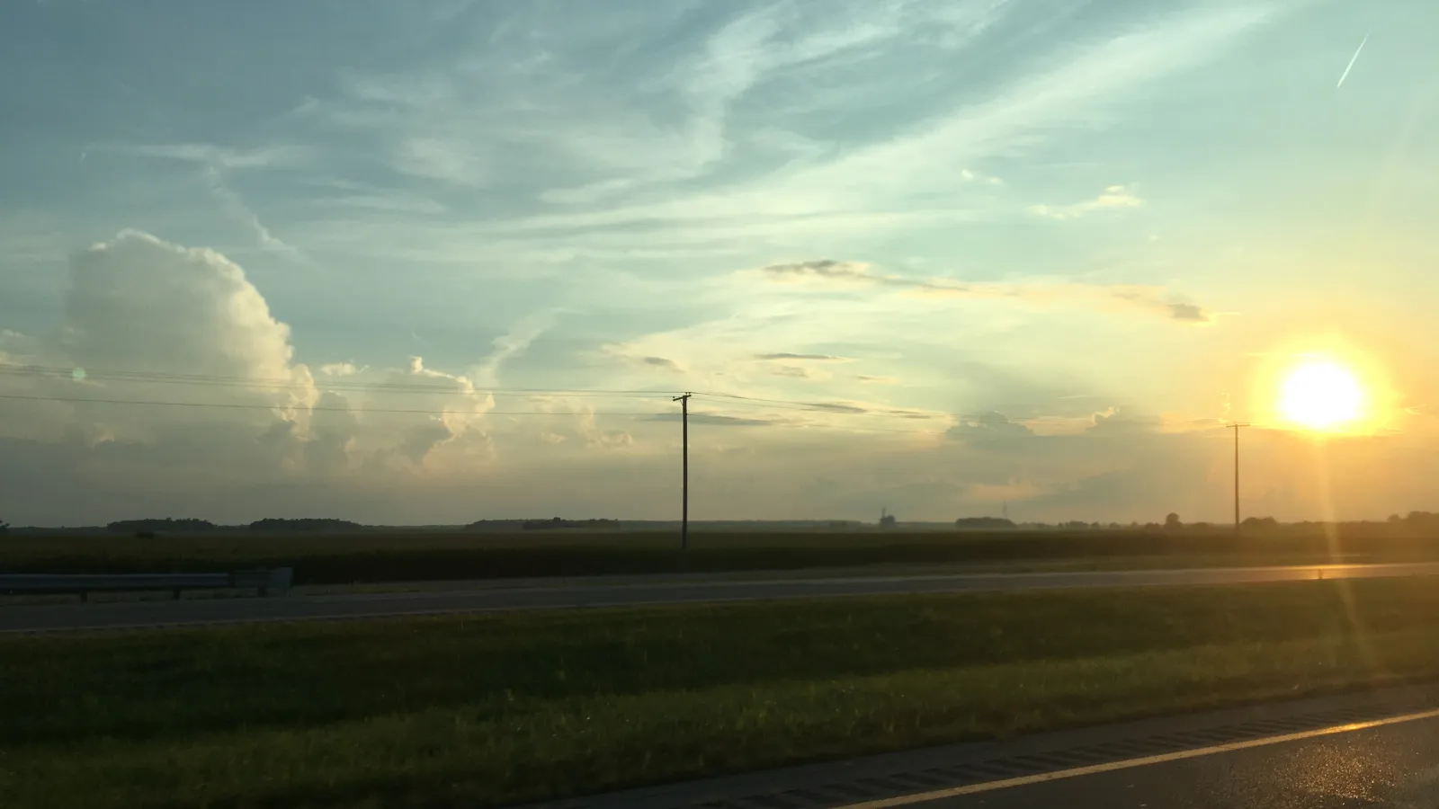 Sunset with clouds and farm field 