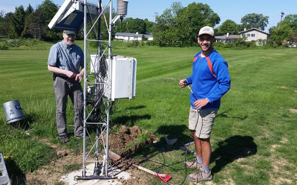 Assistant State Climatologist Jim DeGrand and Undergraduate Research Stephen Maldonado standing near the OARDC-Columbus meteorological tower preparing  to intall soil moisture probes in the ground.  