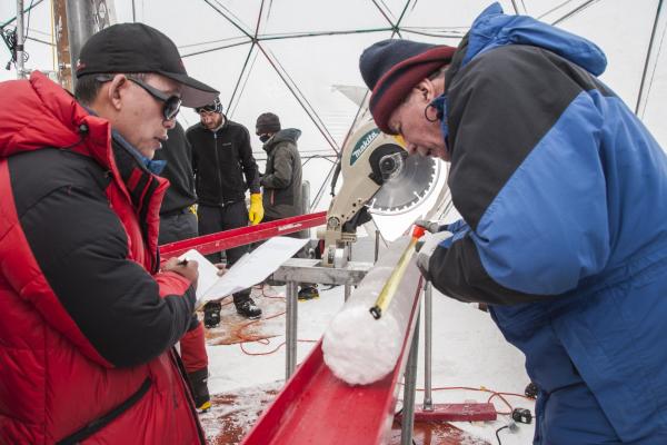 Yao Tandong, left, and Lonnie Thompson, right, process an ice core drilled from the Guliya Ice Cap in the Tibetan Plateau in 2015