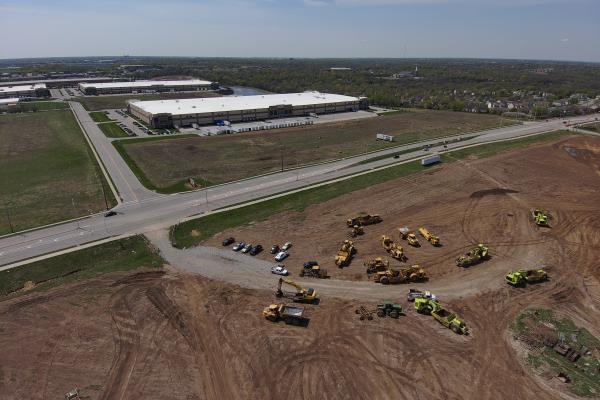 Aerial view of road, warehouse and construction machinery 