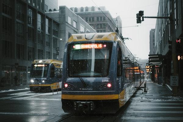 Streetcars on a rainy day in the city with buildings on either side