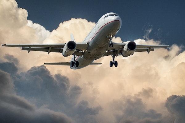 White and Red Plane Beside Clouds Low-angle Photography