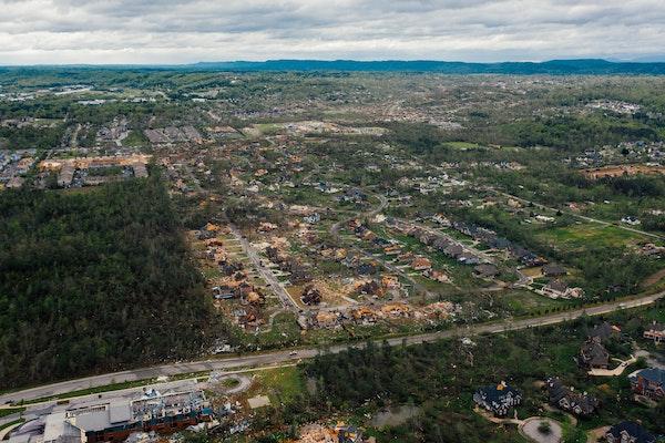 Tornado damage area with houses and uprooted trees