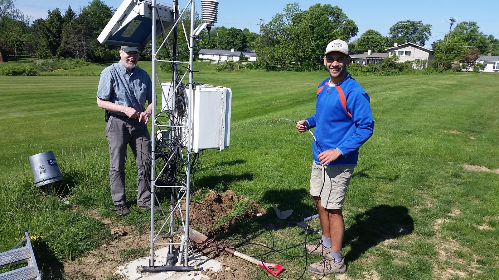 Assistant State Climatologist Jim DeGrand and Undergraduate Research Stephen Maldonado standing near the OARDC-Columbus meteorological tower preparing  to intall soil moisture probes in the ground.  